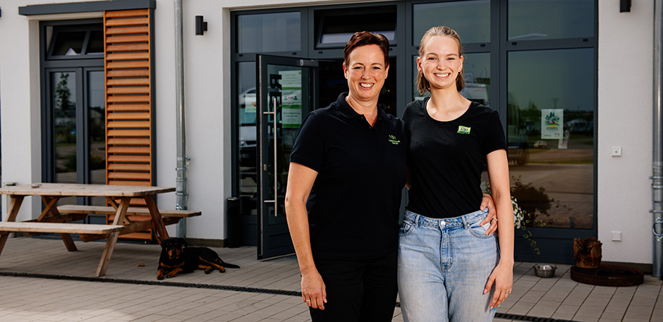 Zwei Frauen stehen vor dem Empfangsgebäude eines Campingplatzes.